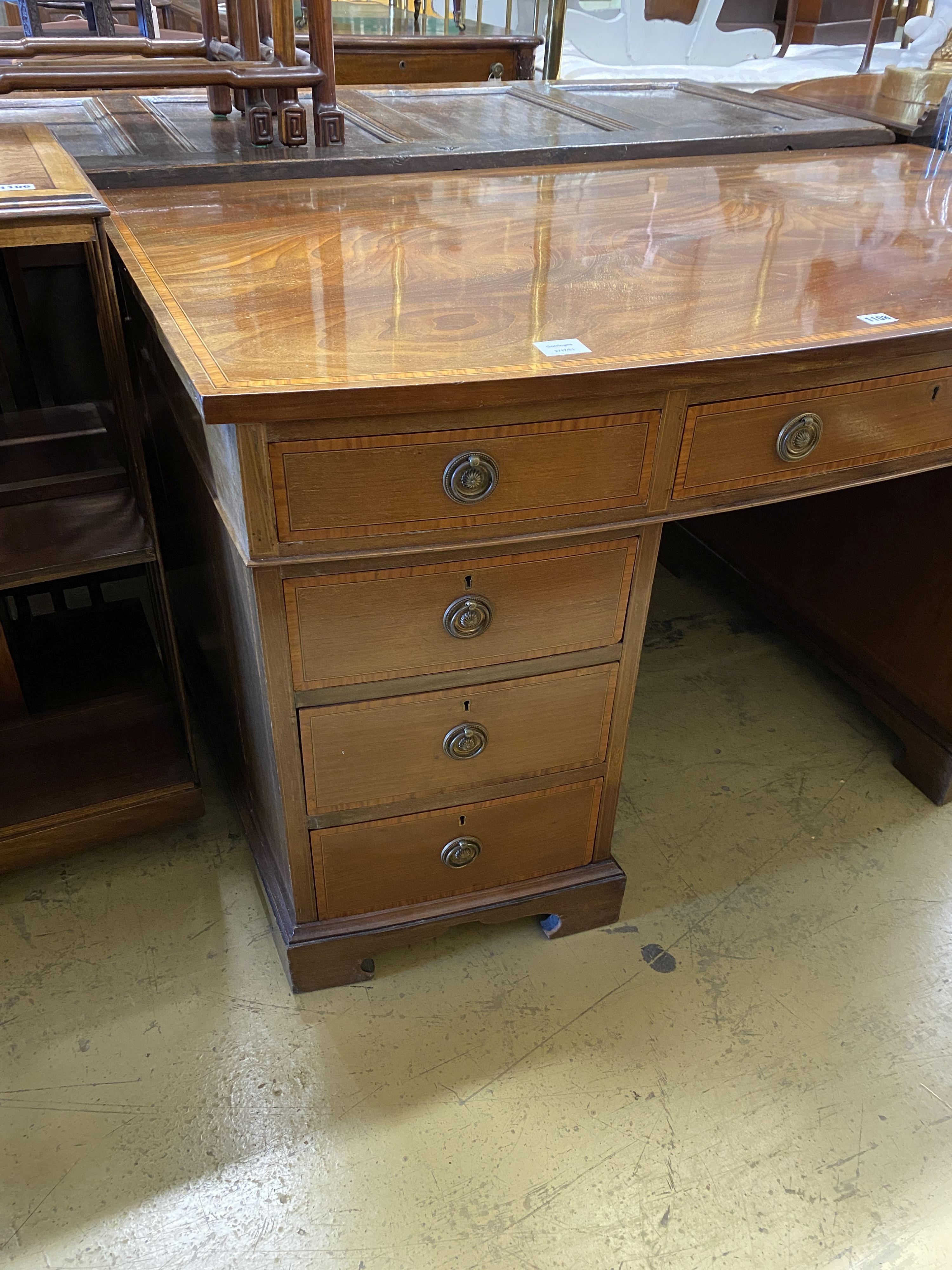 An Edwardian satinwood banded mahogany bow front kneehole pedestal desk, width 137cm, depth 76cm, height 74cm